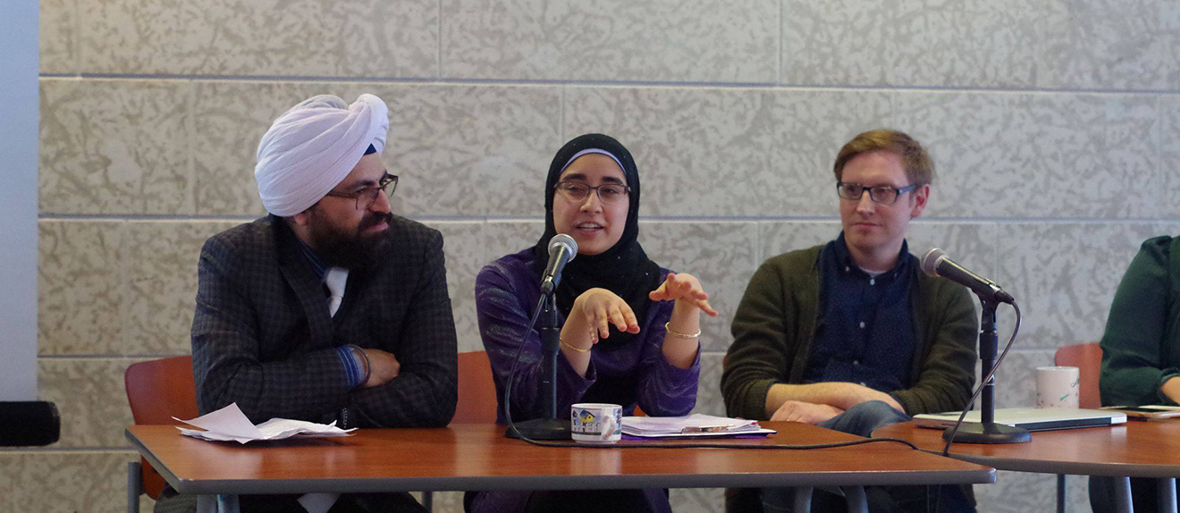 3 students sitting at a table presenting